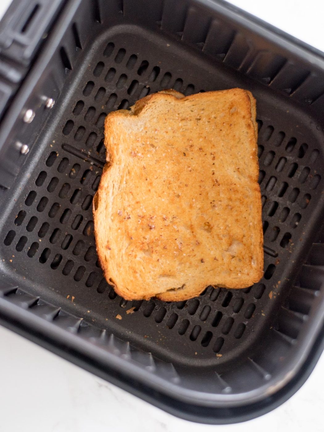 a grilled cheese sandwich inside of an air fryer basket