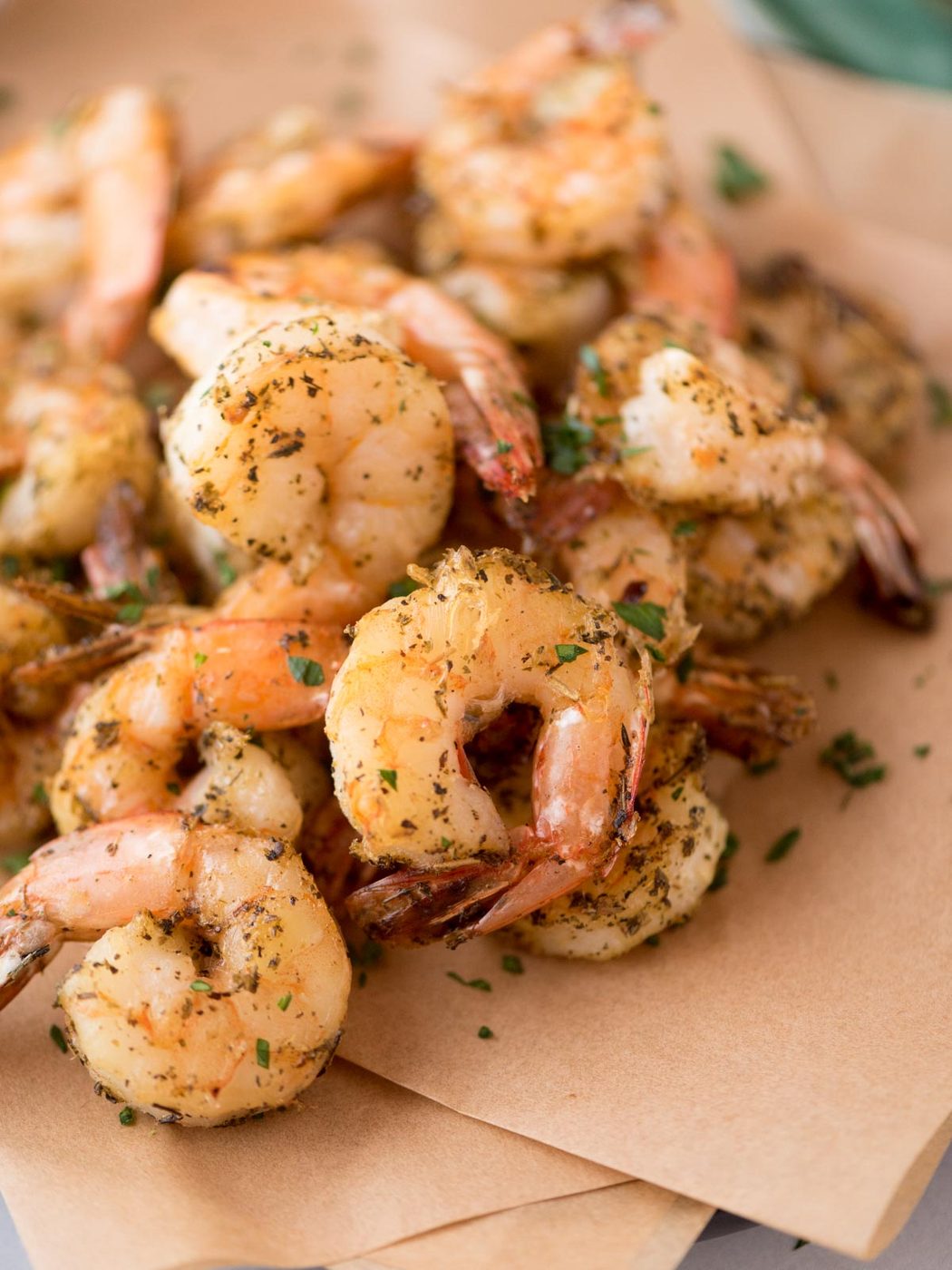 Air fryer shrimp laying over parchment paper.