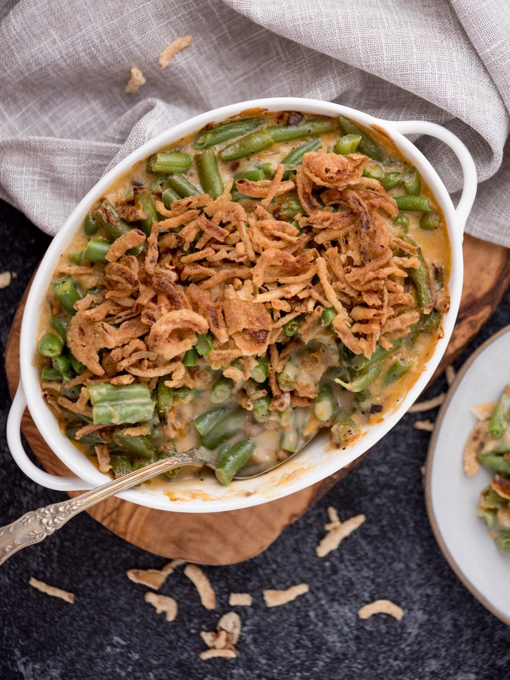 Spoon tucked into the white baking dish of green bean casserole.