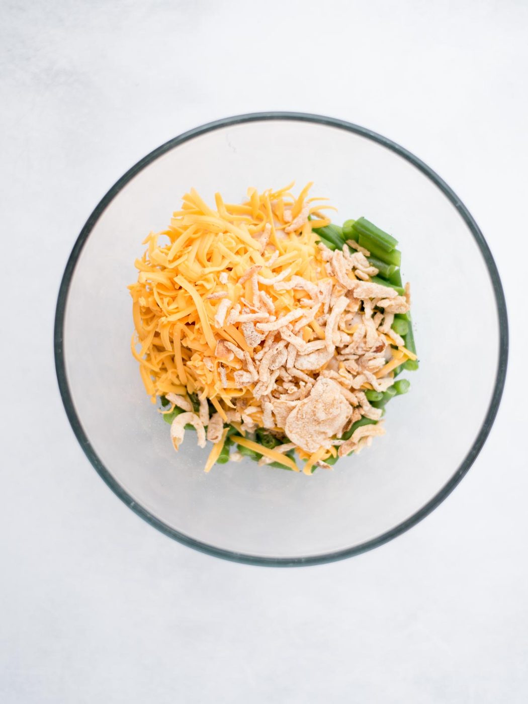 Mixing bowl filled with ingredients to make green bean casserole.