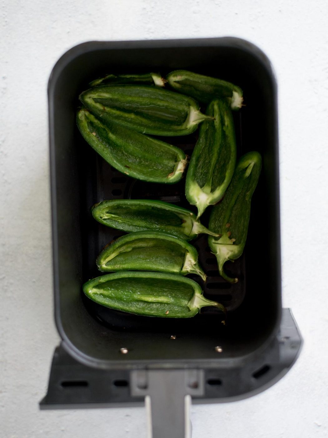 par baked jalapenos in an air fryer basket