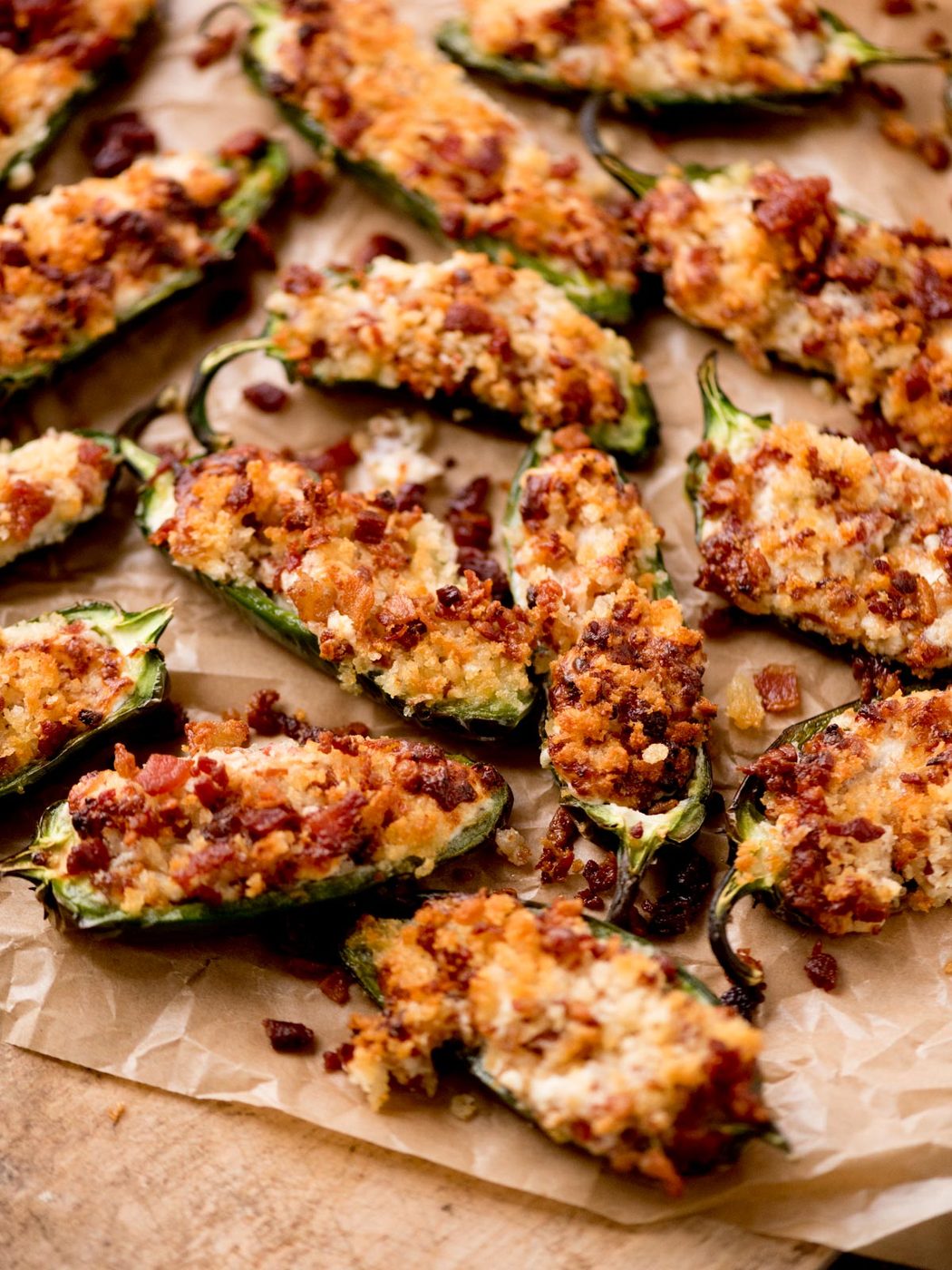 air fryer jalapeno poppers on a parchment paper sitting on top of a bread board