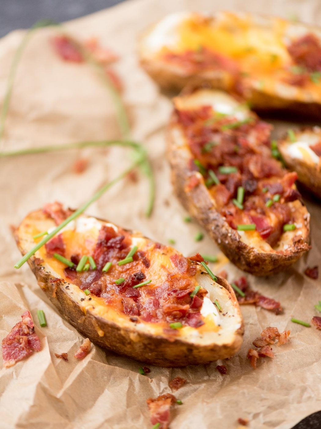 Air fryer potato skins with bacon, cheese and chive ready to serve.