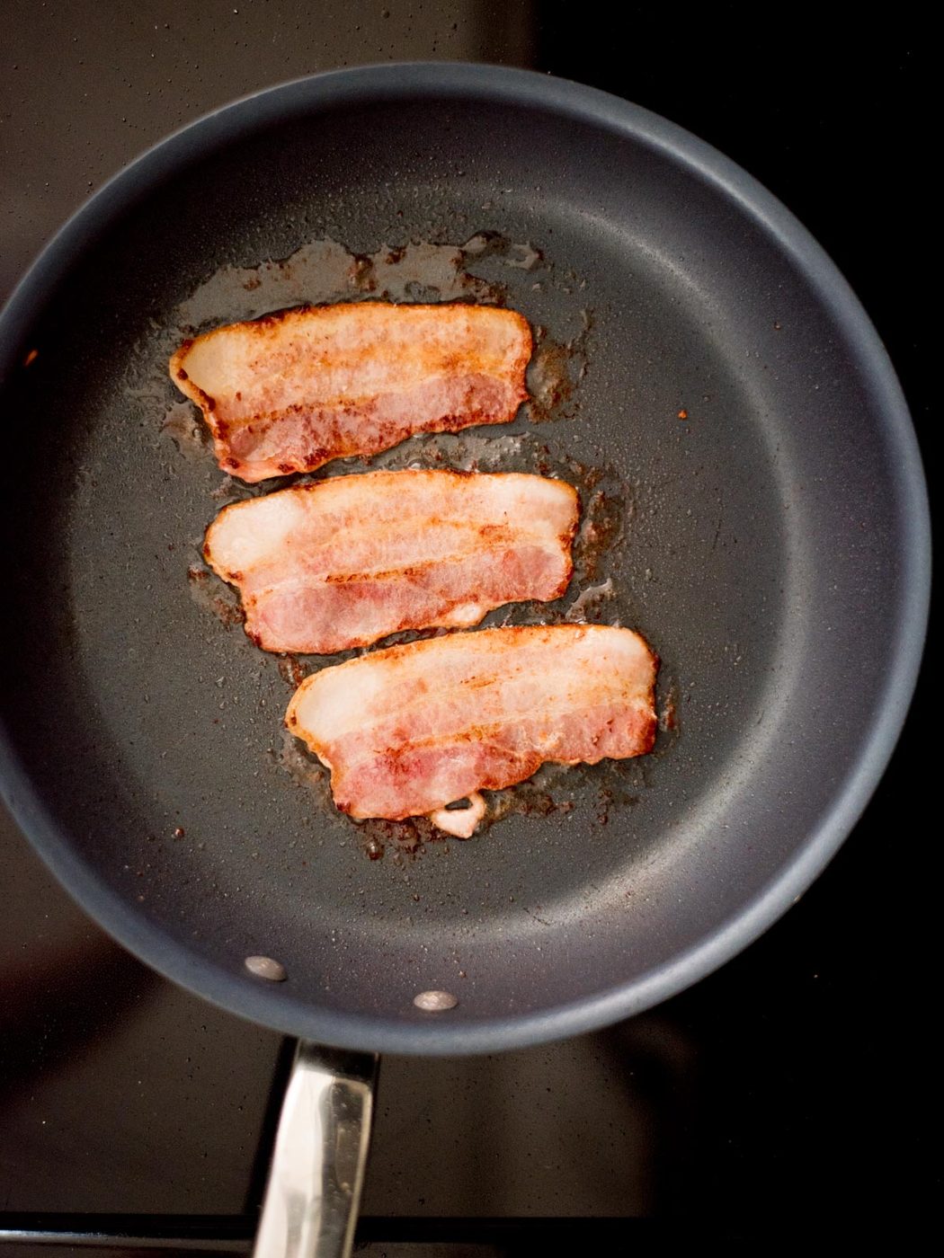 Bacon frying in a pan.