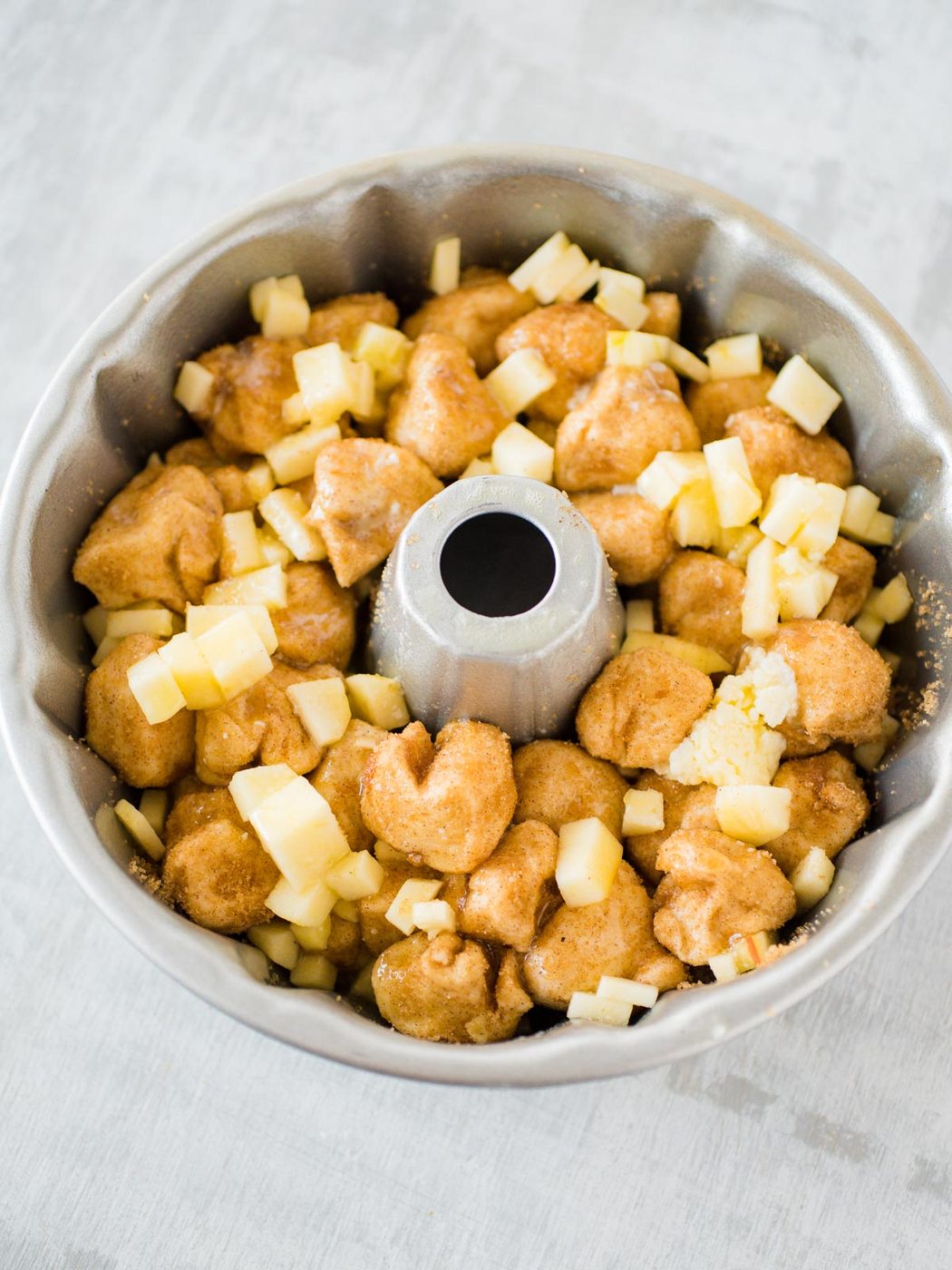 raw apple cinnamon monkey bread in a Bundt pan