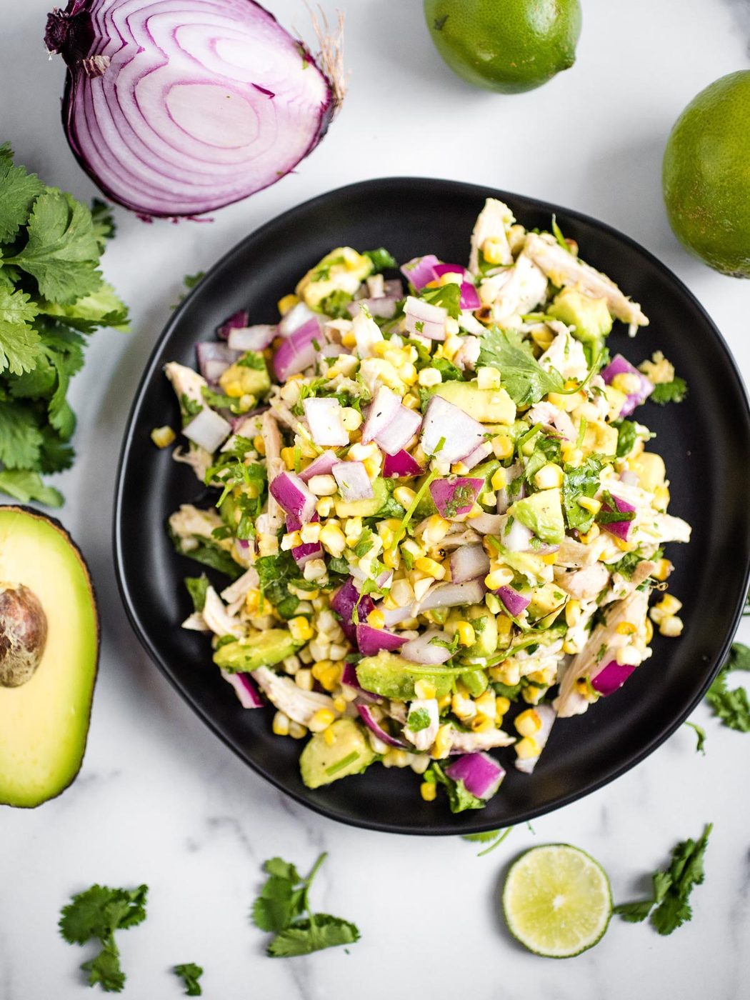 avocado chicken chopped salad on a black plate