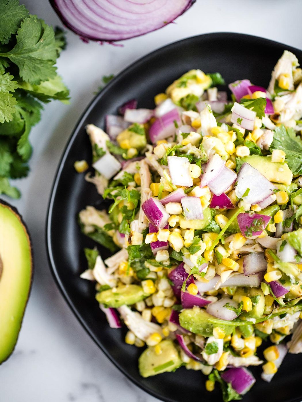 avocado chicken chopped salad on a black plate