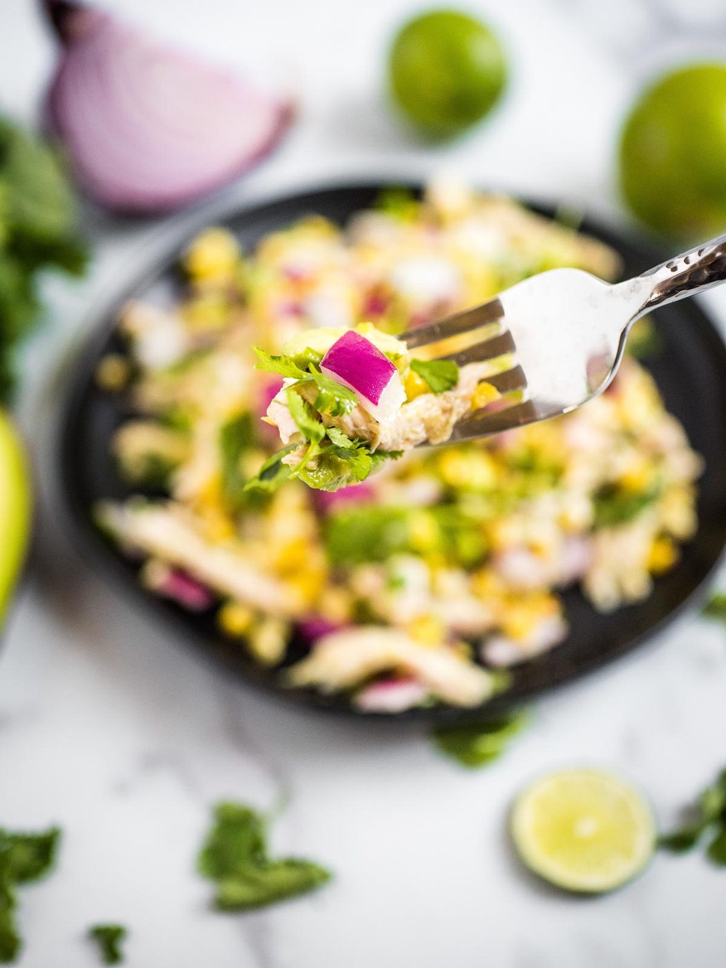 a bite of avocado chicken chopped salad on a silver fork