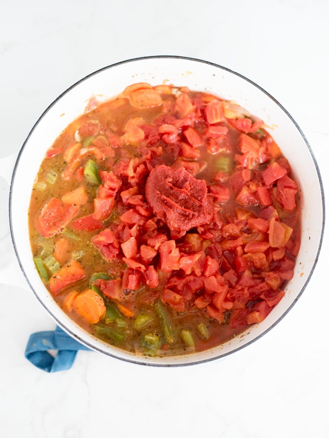 chicken broth, tomato paste, and diced tomatoes added to the dutch oven with the vegetables and wine