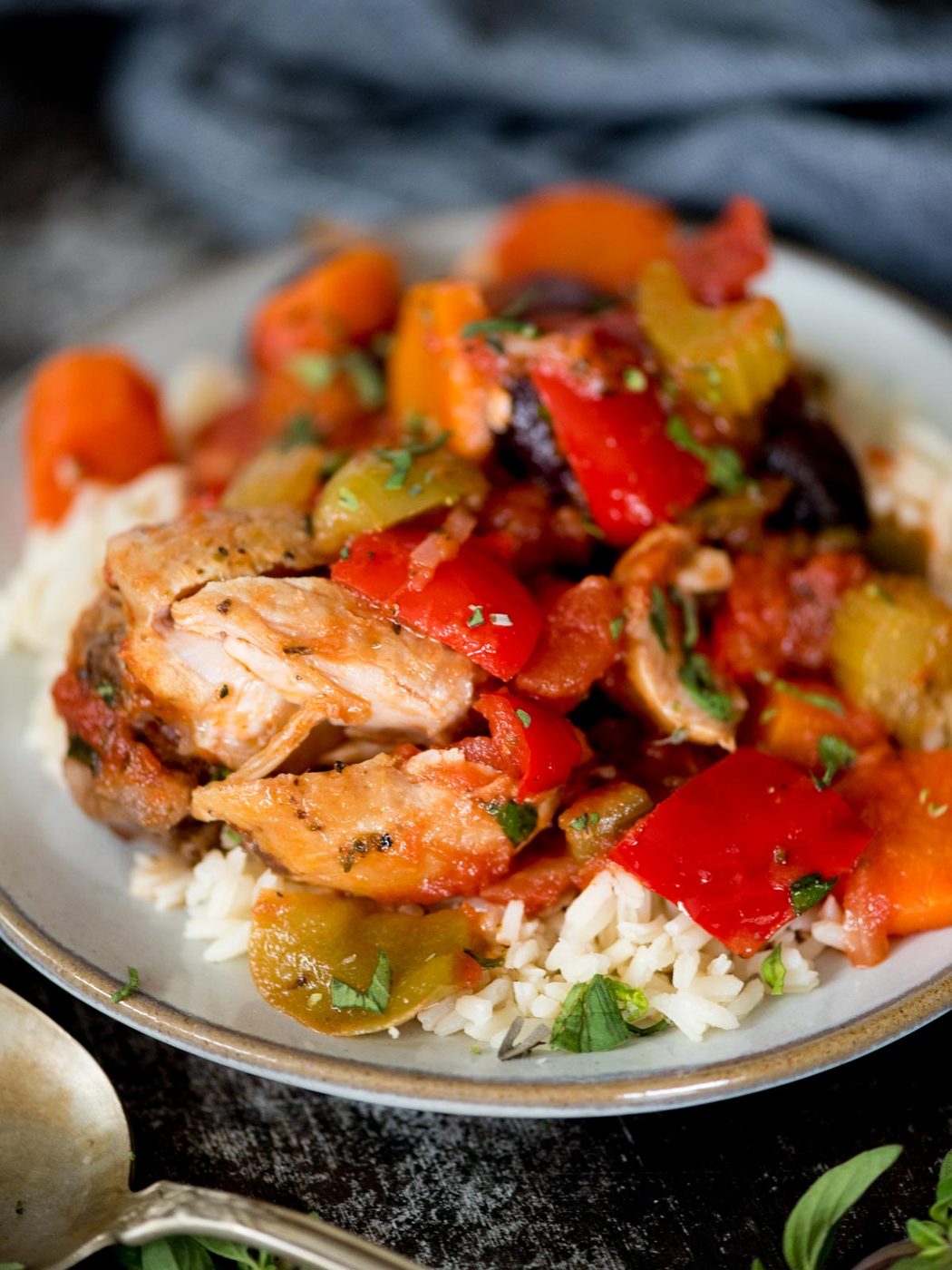 baked chicken cacciatore on top of white rice topped with fresh oregano