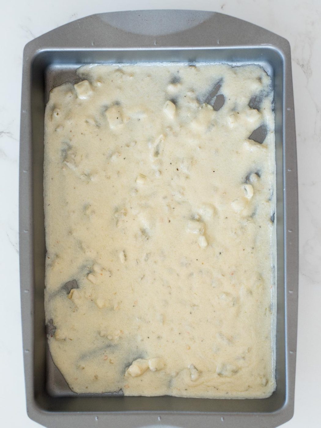 pan with green chile enchilada sauce in the bottom