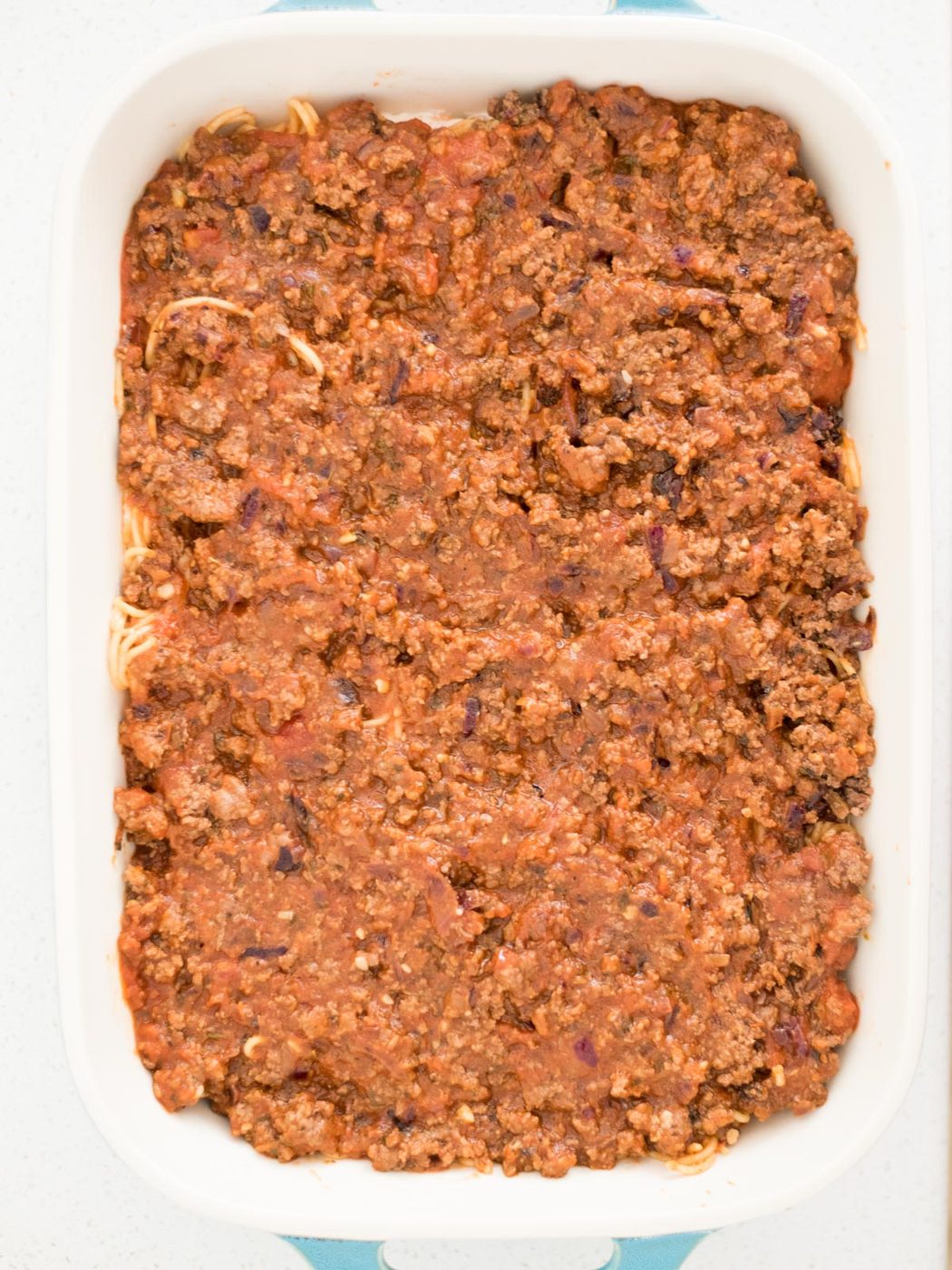 meat sauce poured over the top of the spaghetti mix