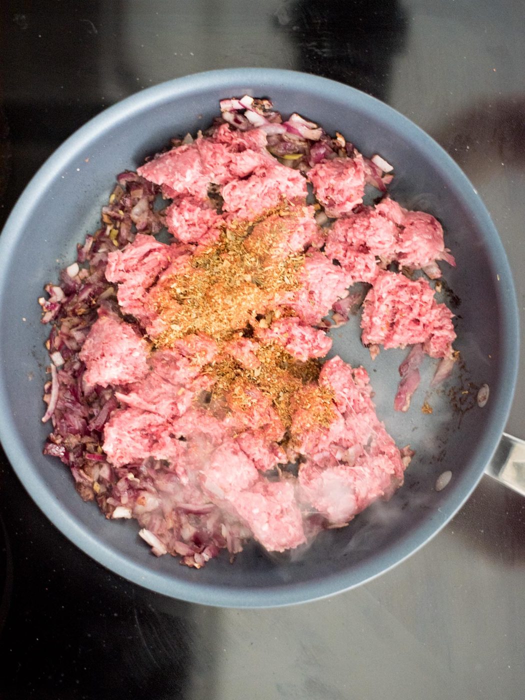 ground beef, seasonings, and onions in a skillet
