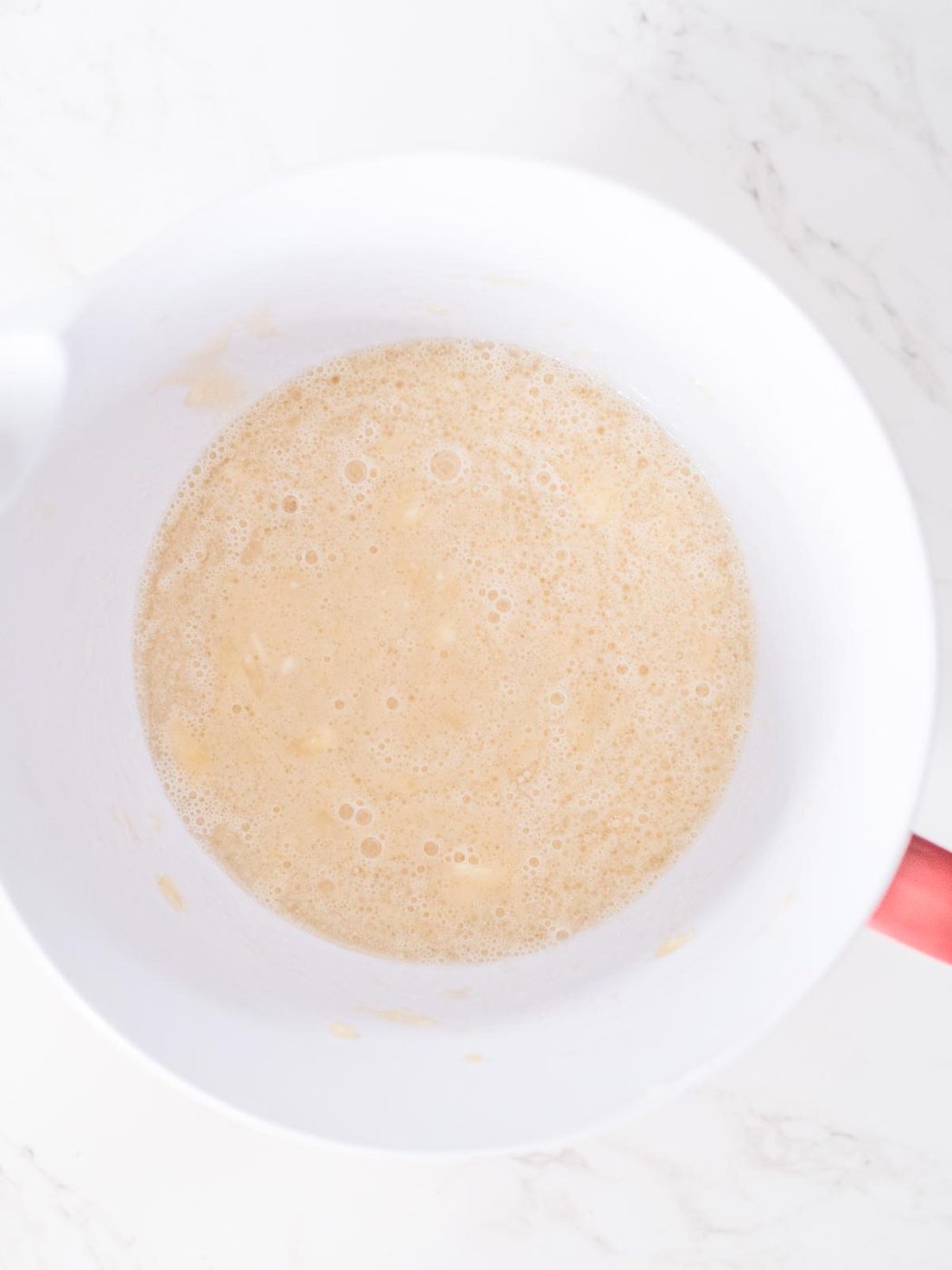 wet ingredients for banana muffins mixed together in a mixing bowl