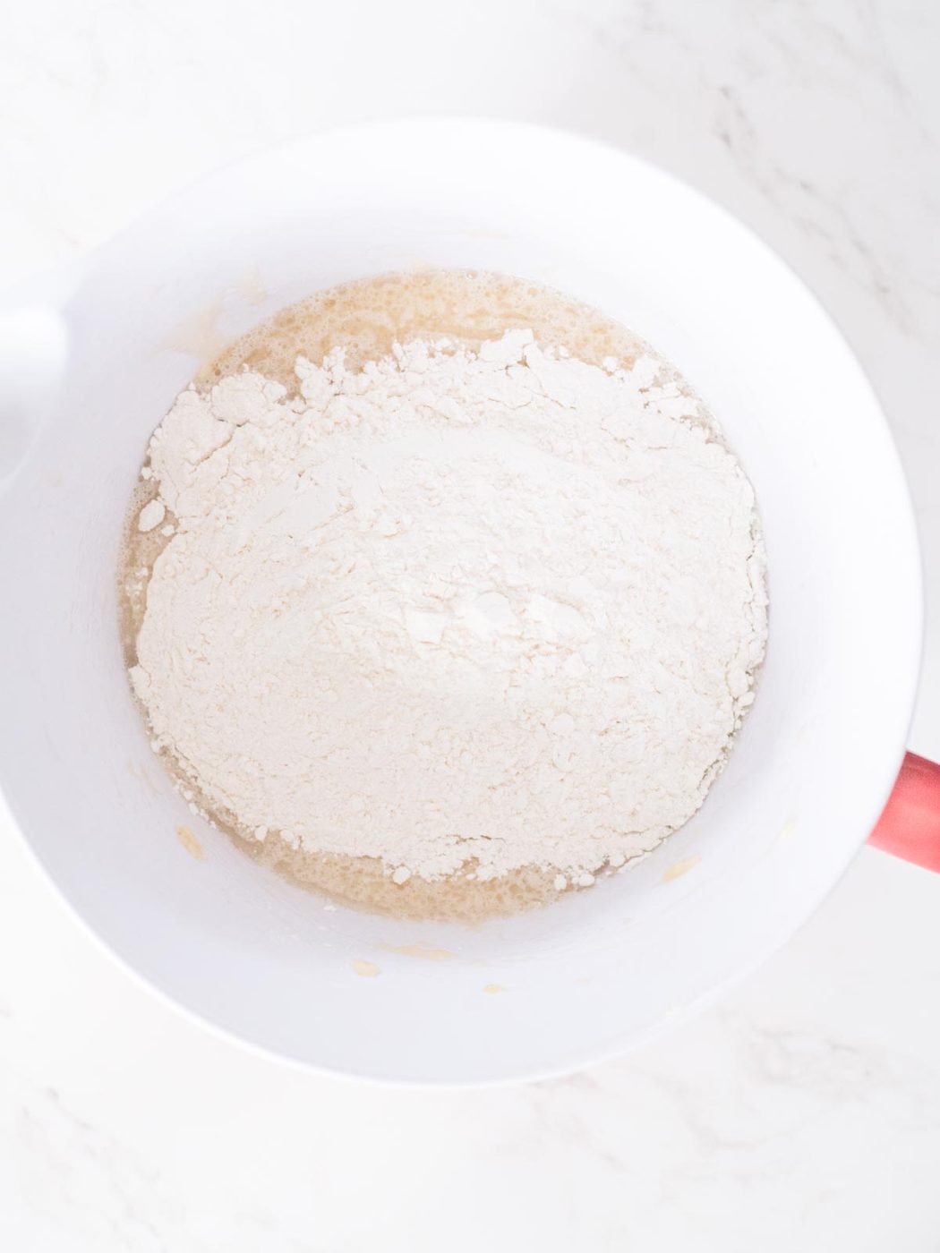 combining the wet and dry ingredients in a mixing bowl for banana muffins