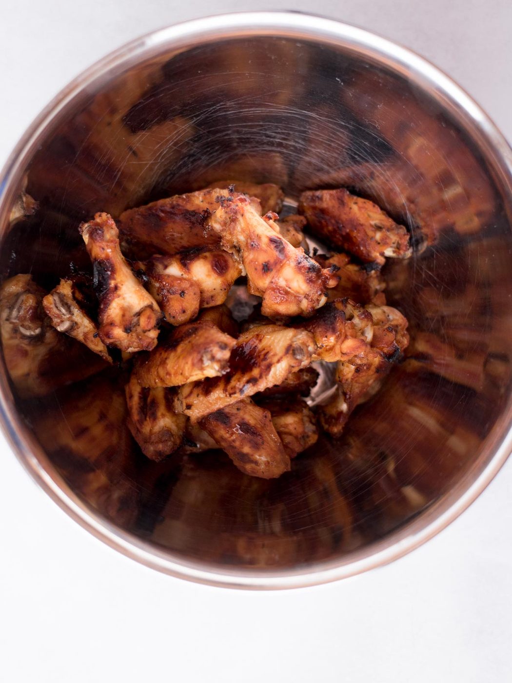 cooked bbq wings in a mixing bowl