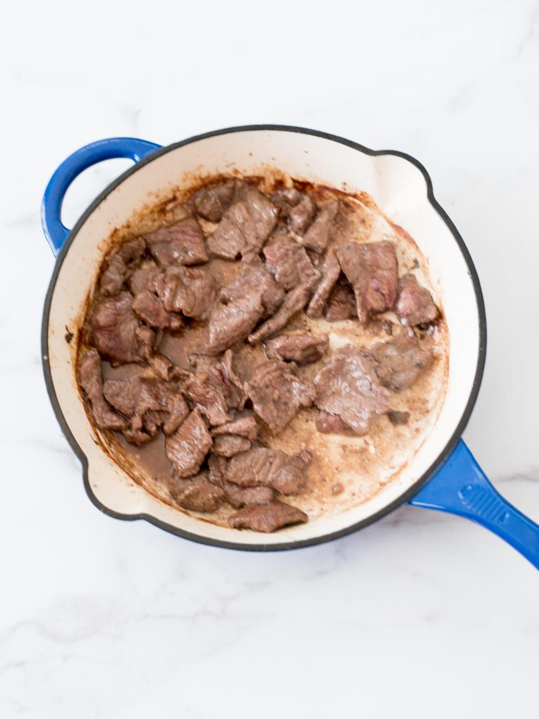 beef cooking in a skillet