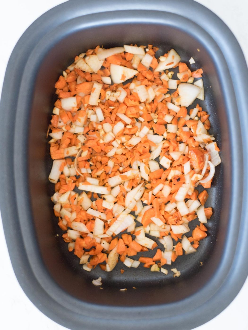 carrots, onion, and garlic being sautéed