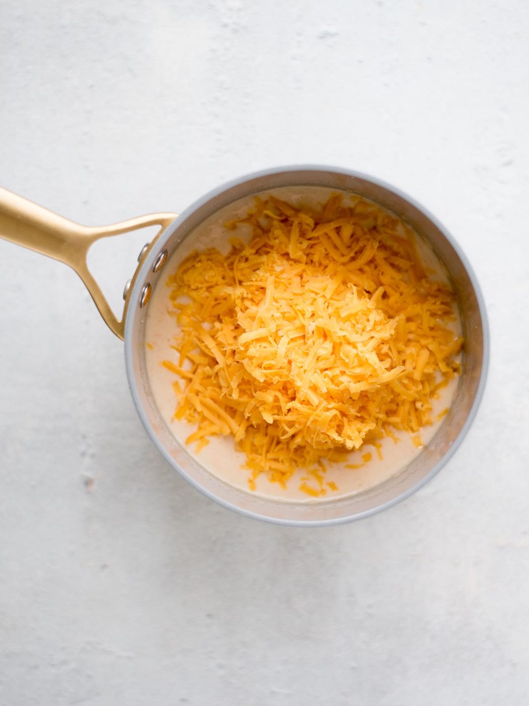 sharp cheddar cheese added to the saucepan