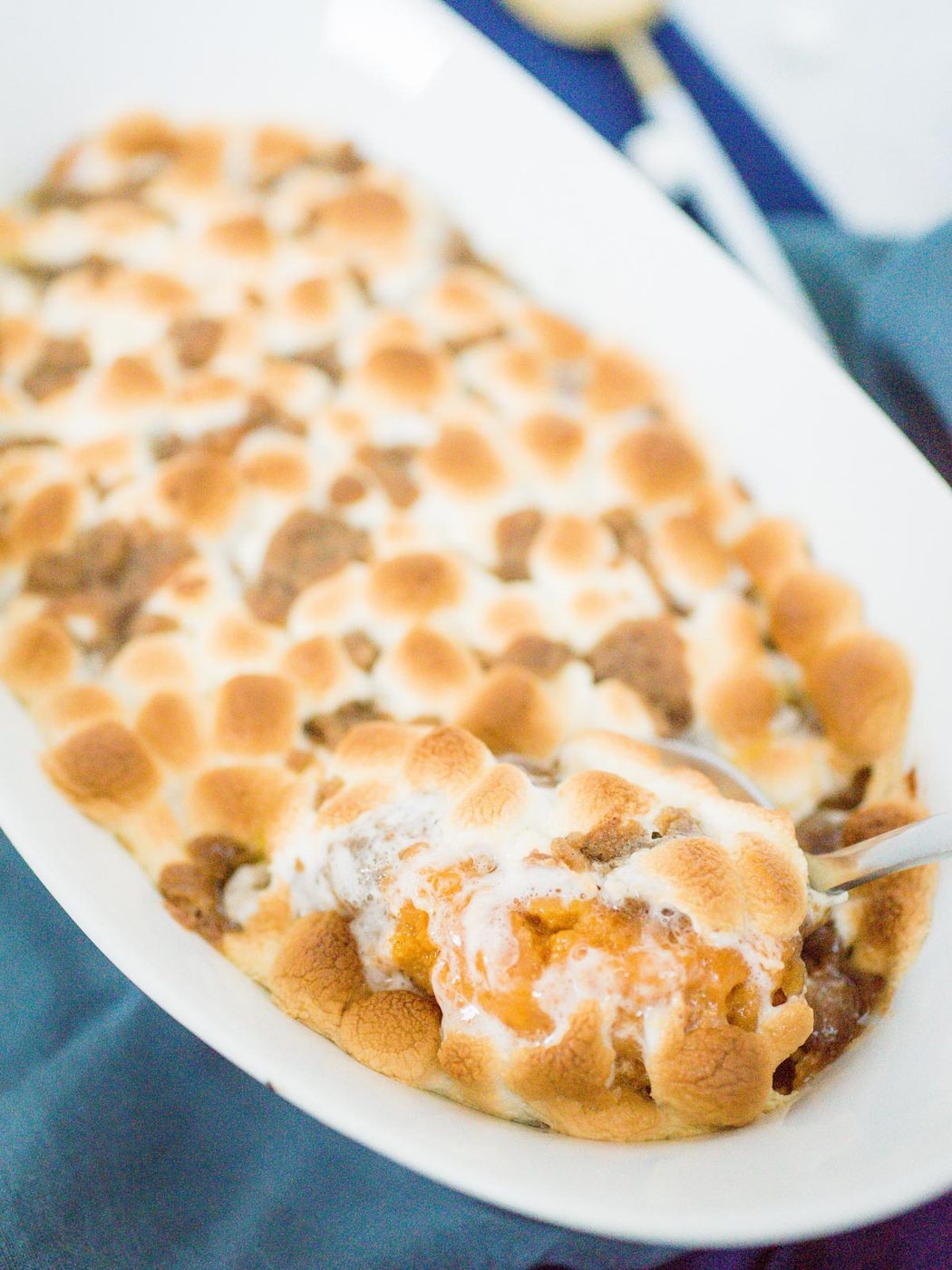 sweet potato casserole being scooped out of a baking dish