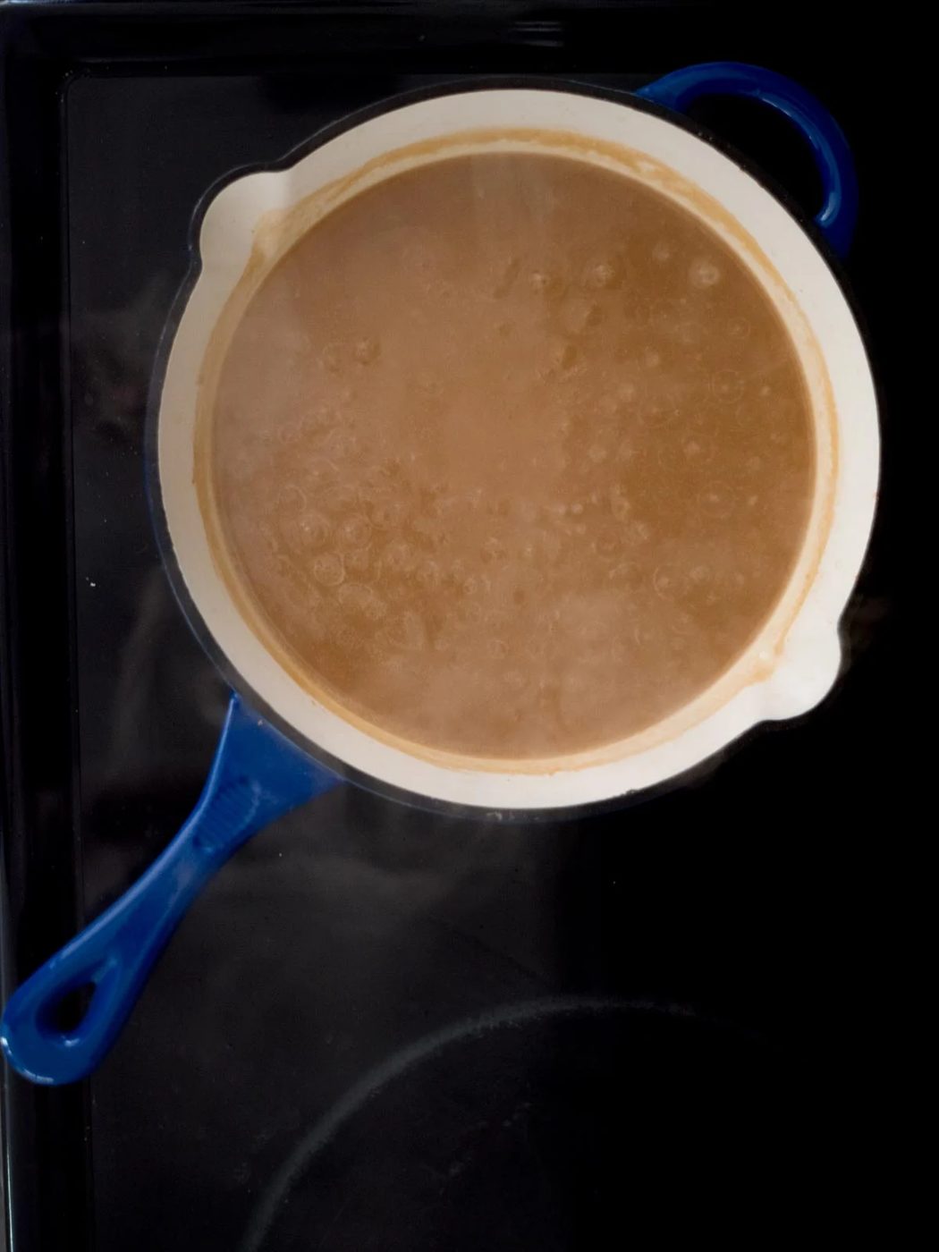 brown gravy simmering in a skillet on the stove