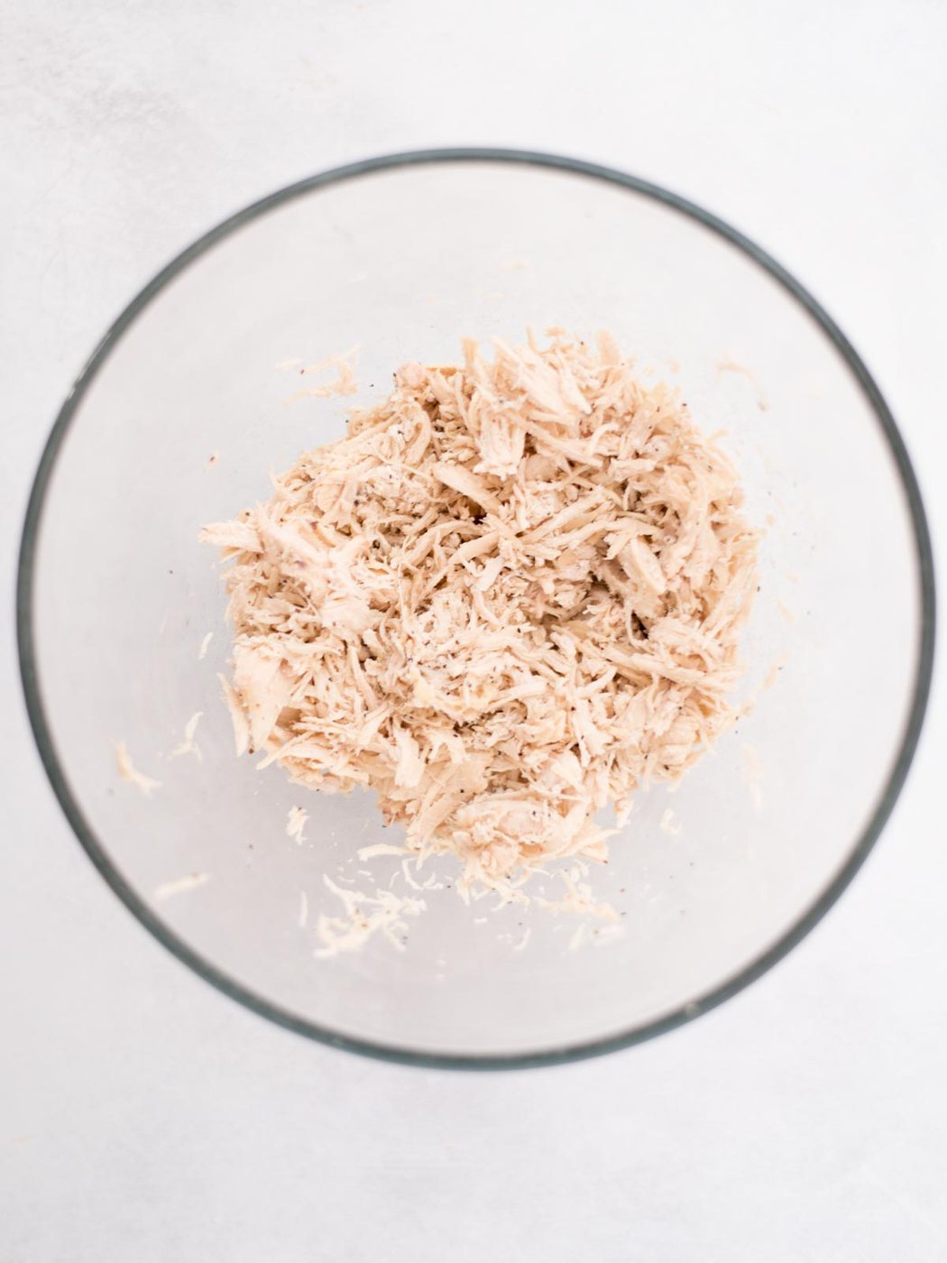 Shredded chicken in a mixing bowl.