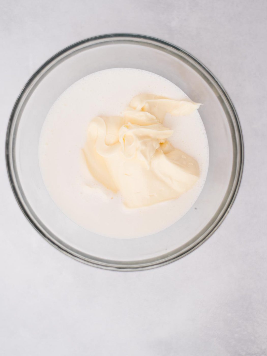 Buttermilk and mayonnaise added to a mixing bowl.