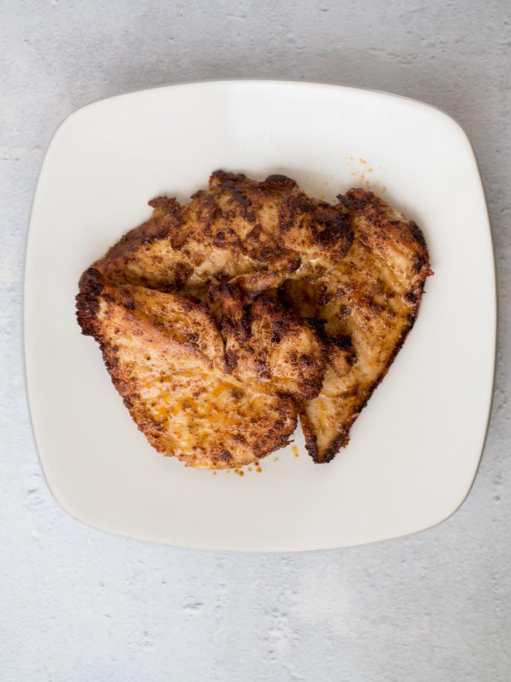 cooked cajun chicken on a white plate