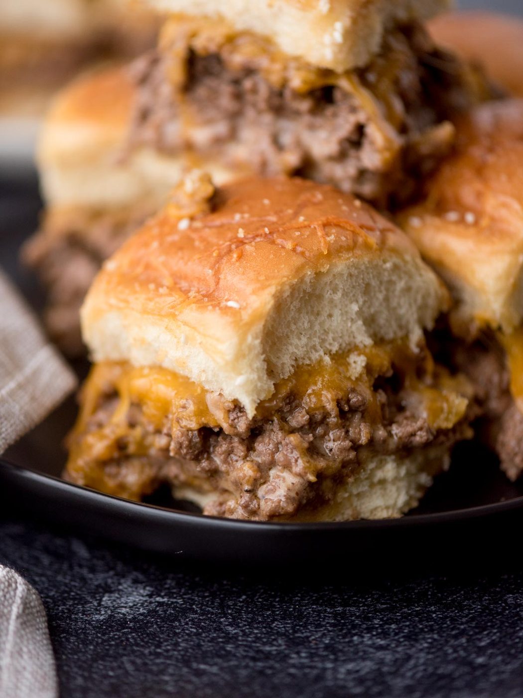 stack of cheeseburger sliders on a black plate