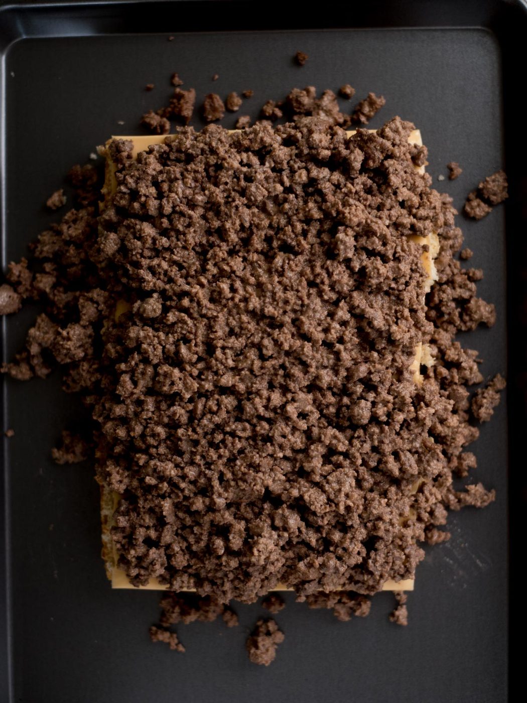ground beef mixture on top of the bottom part of the buns with cheese