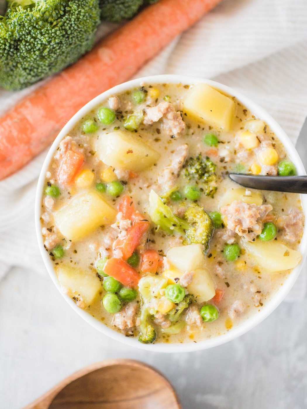 a bowl of soup with a black spoon inside the bowl