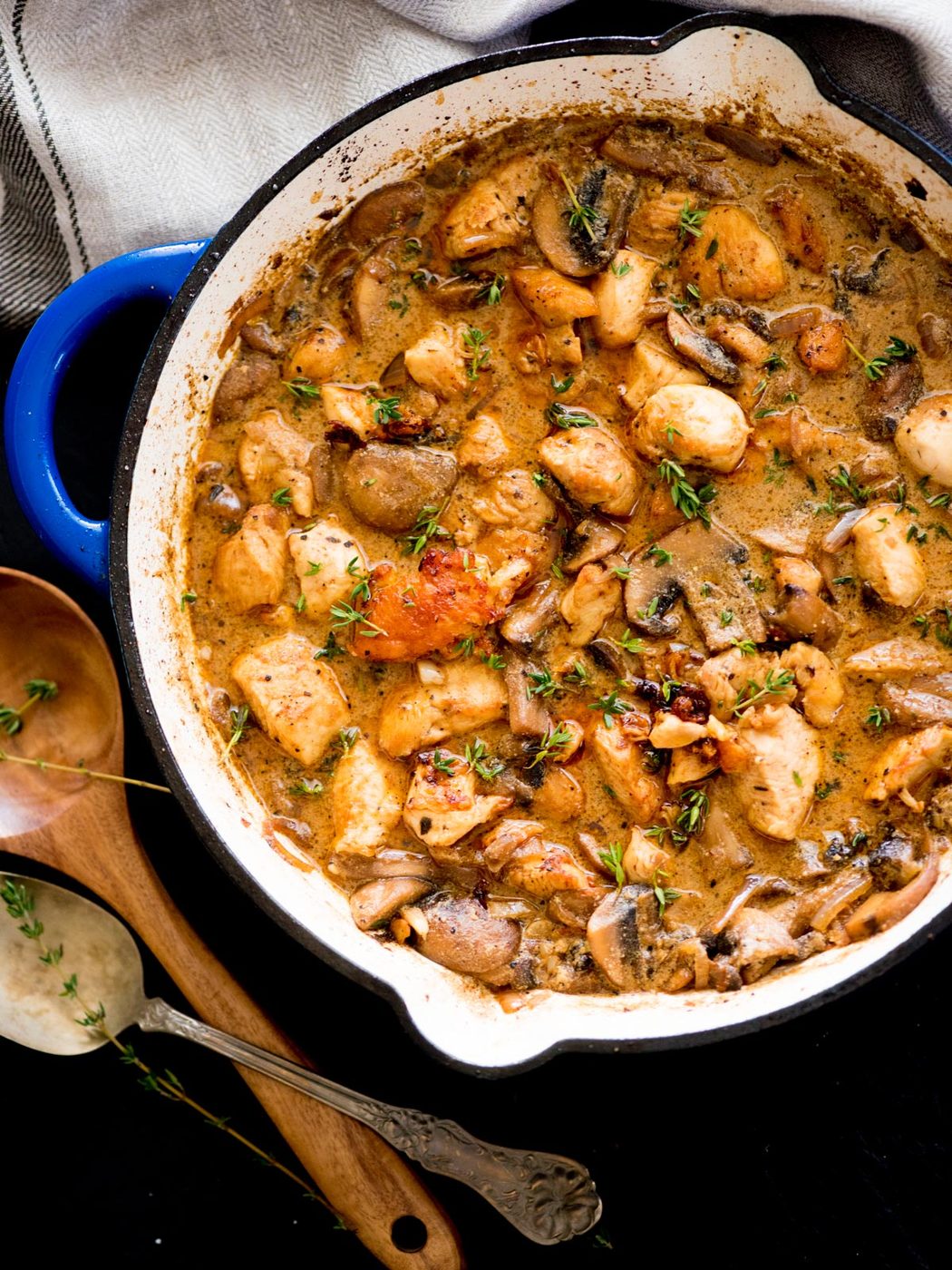 chicken and mushroom stroganoff in a skillet topped with fresh thyme