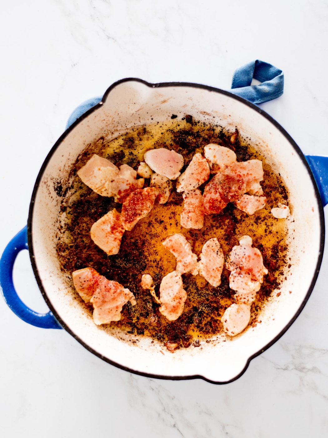 seasoned chicken in a skillet searing