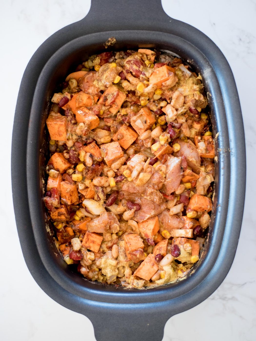 ingredients for chicken chili uncooked in the crock pot