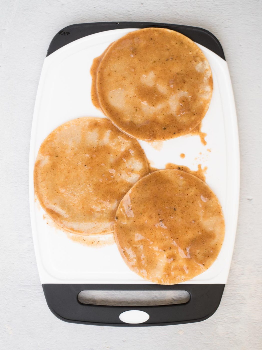 sauced tortillas on a cutting board