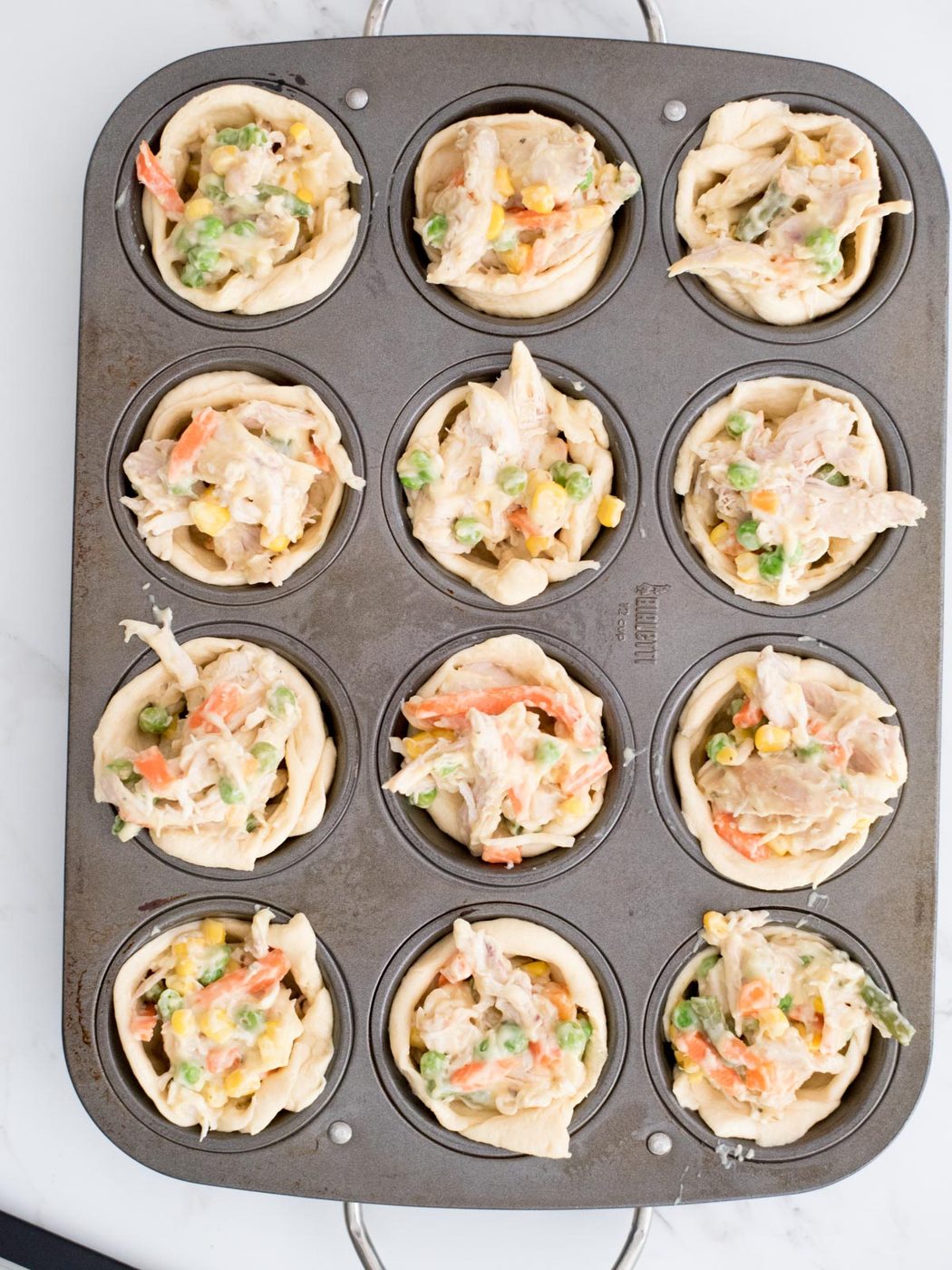 unbaked chicken pot pie bites in a muffin tin
