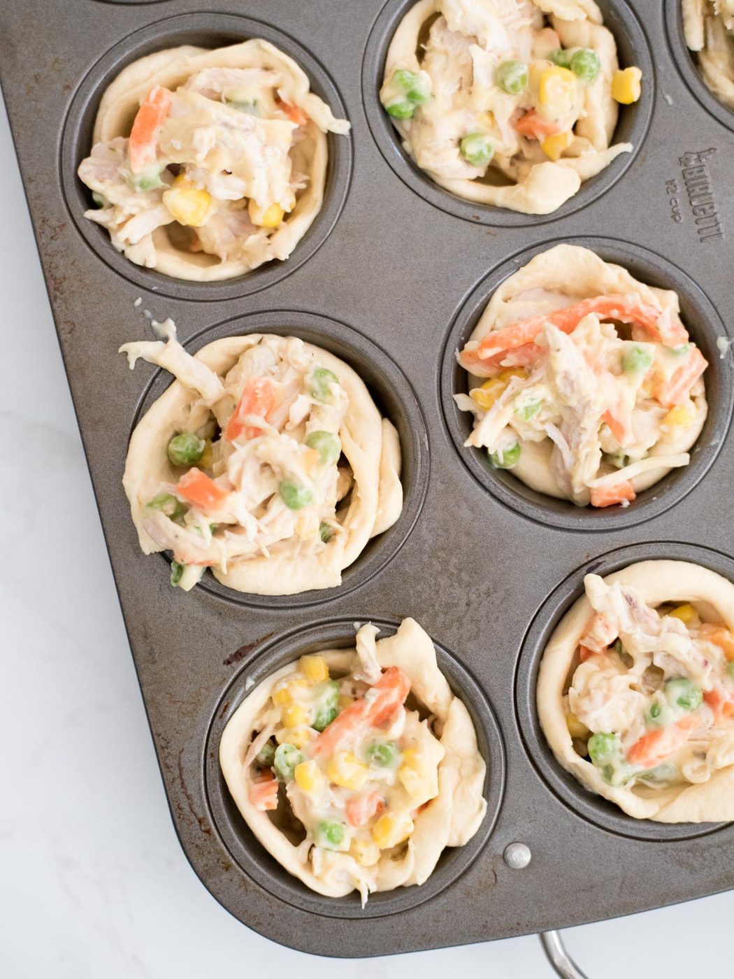 chicken pot pie bites in a muffin tin unbaked