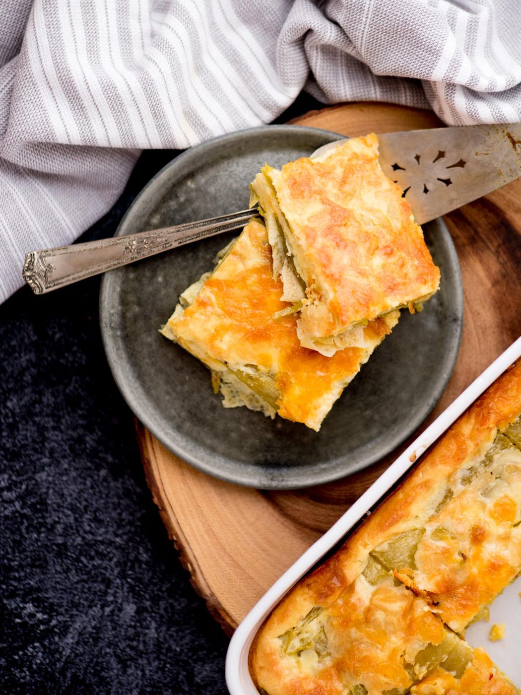 Hatch Chile Relleno slices on a plate next to the baking dish.
