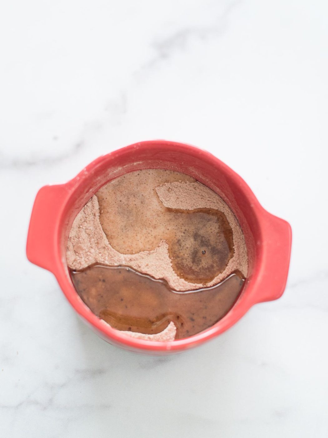 wet ingredients added to dry ingredients in mug
