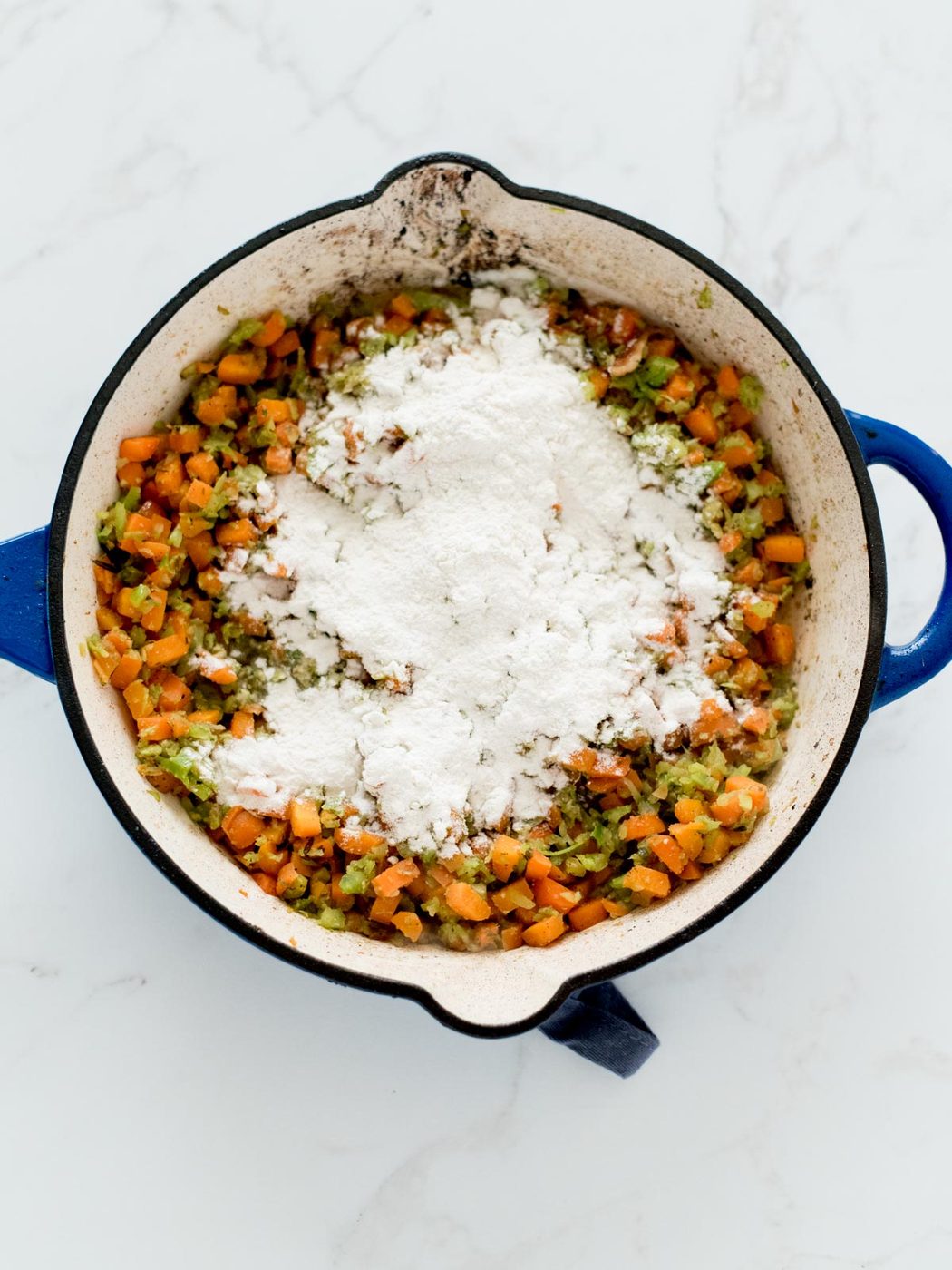 sautéed vegetables in a skillet with flour