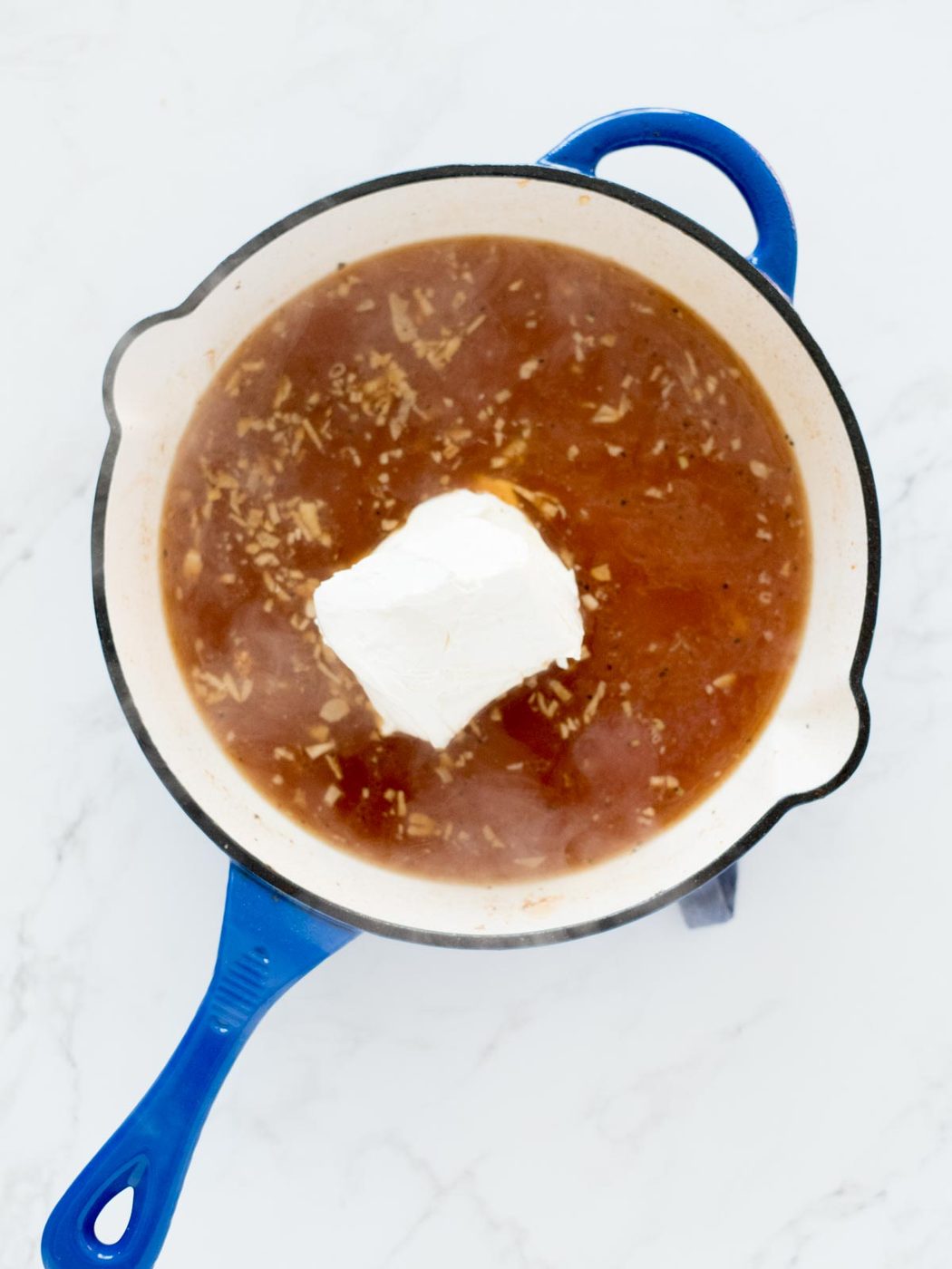 broth and cream cheese added to skillet