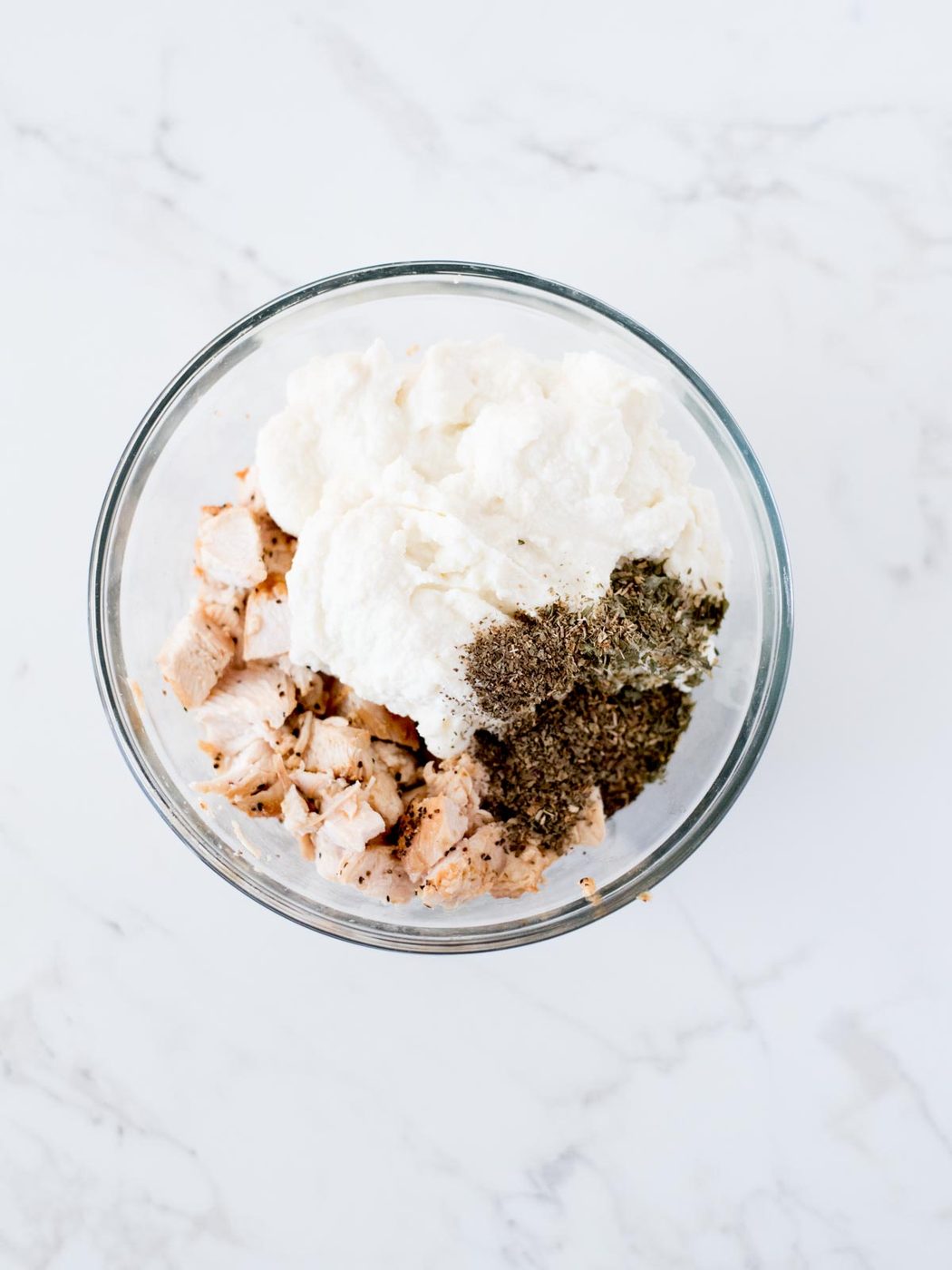 ricotta, spices, and chicken in mixing bowl