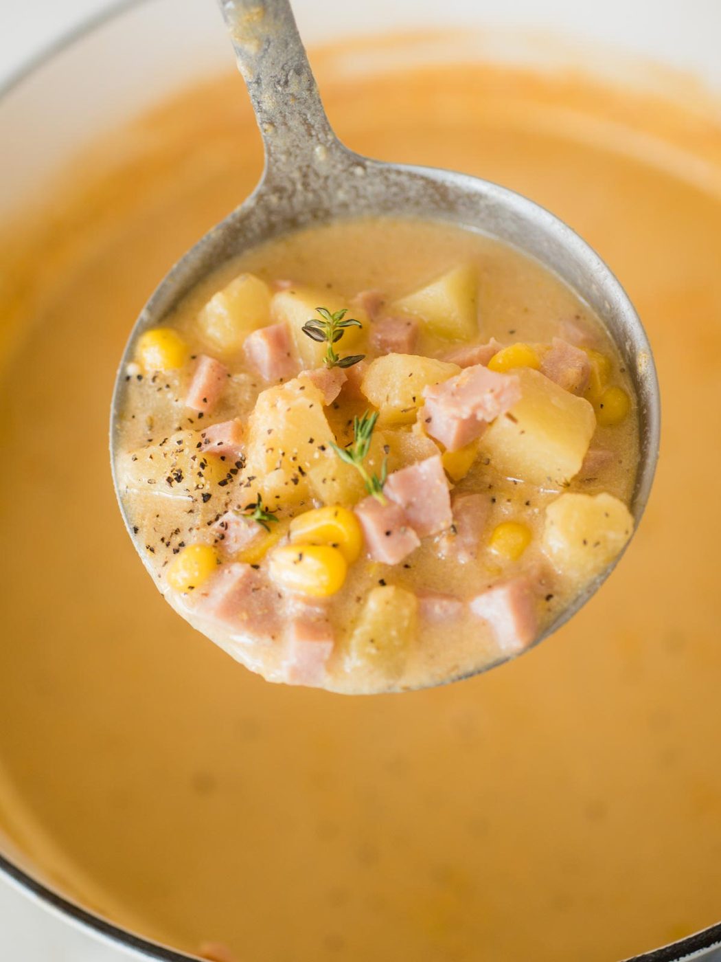 ladel full of creamy ham and potato corn chowder