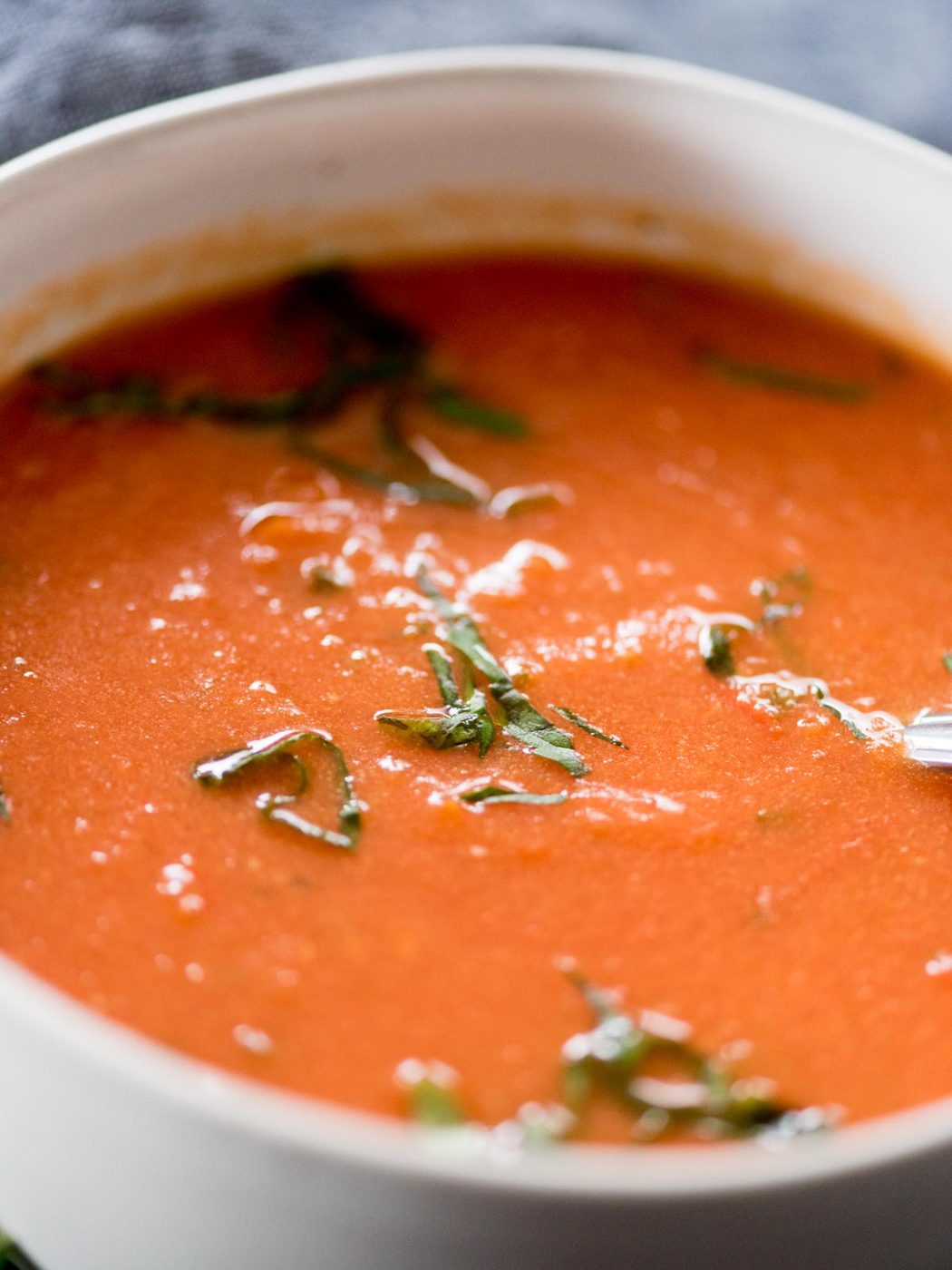 roasted tomato basil soup in a bowl topped with basil
