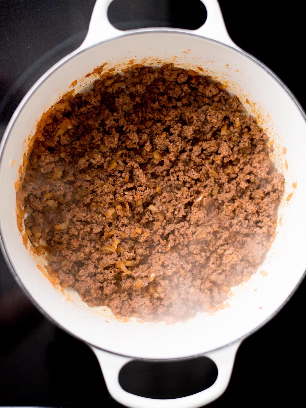 Ground beef and onions cooked in a dutch oven.