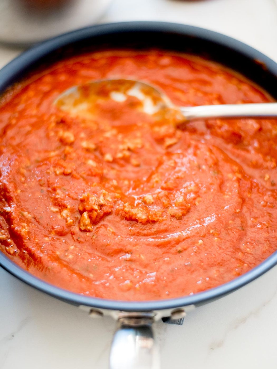 pasta sauce and italian sausage mixed together in a skillet