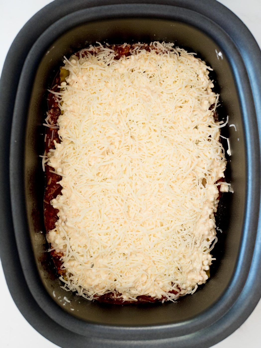 shredded mozzarella over cheese mix in crockpot