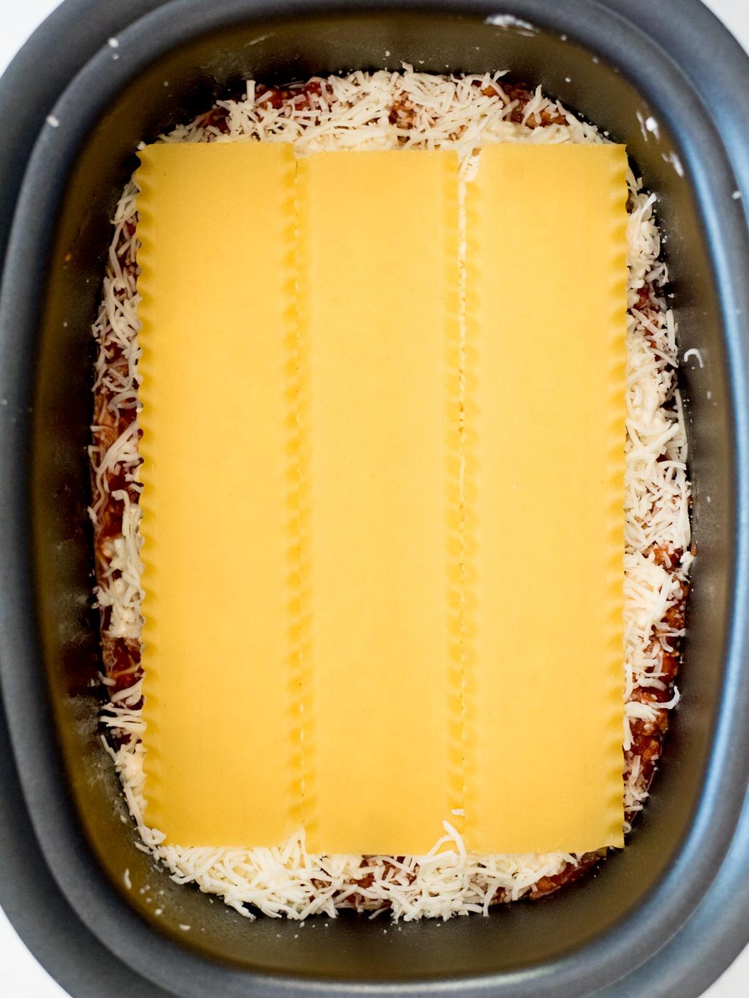 noodles over shredded mozzarella in the crockpot