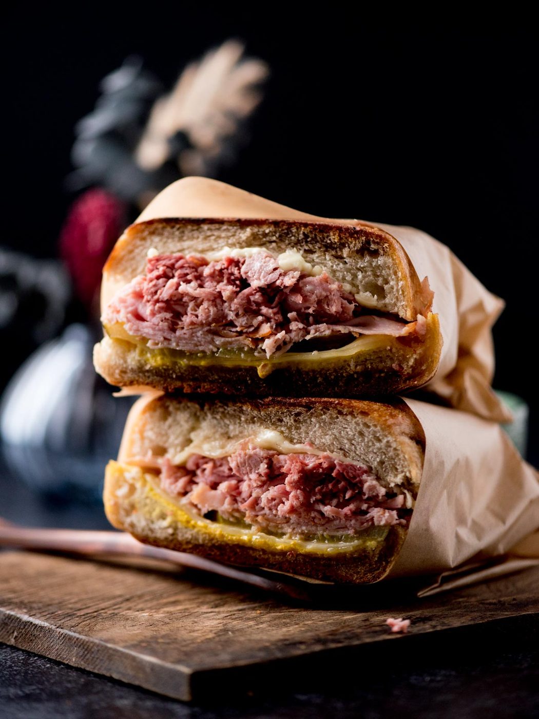 stacked cuban sandwiches on a bread board