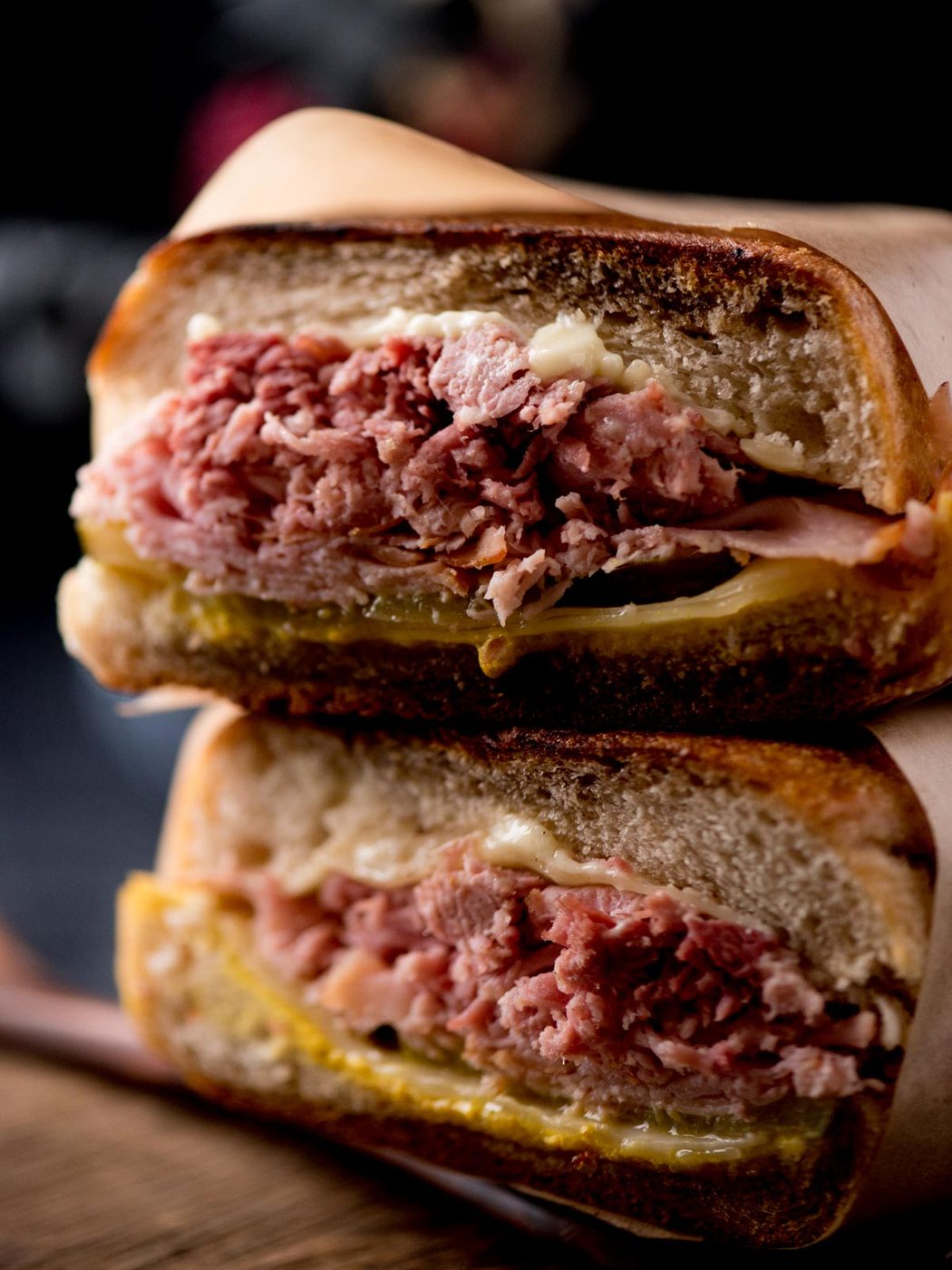 stacked cuban sandwiches on a bread board
